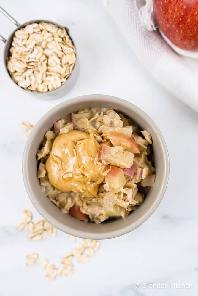 Microwave apple peanut butter oatmeal with fresh apples, rolled oats, and peanut butter in a bowl.