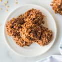 No bake peanut butter oatmeal cookies on a plate with loose oats on the side. 