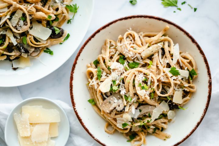 Mushroom pasta with a creamy sauce in a bowl with a spoon.