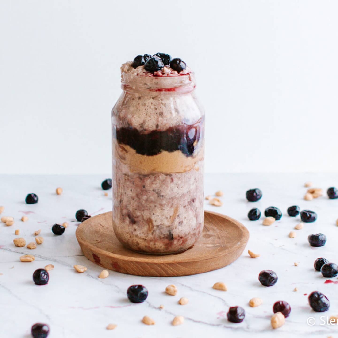 PBJ overnight oats in a mason jar with a layer of grape jelly and peanut butter. 