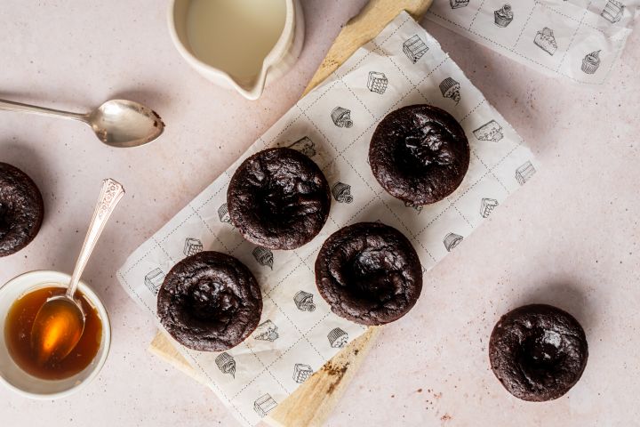 Flourless Pumpkin Brownie Bites with canned pumpkin and almond butter on a wooden cutting board with maple syrup on the side.