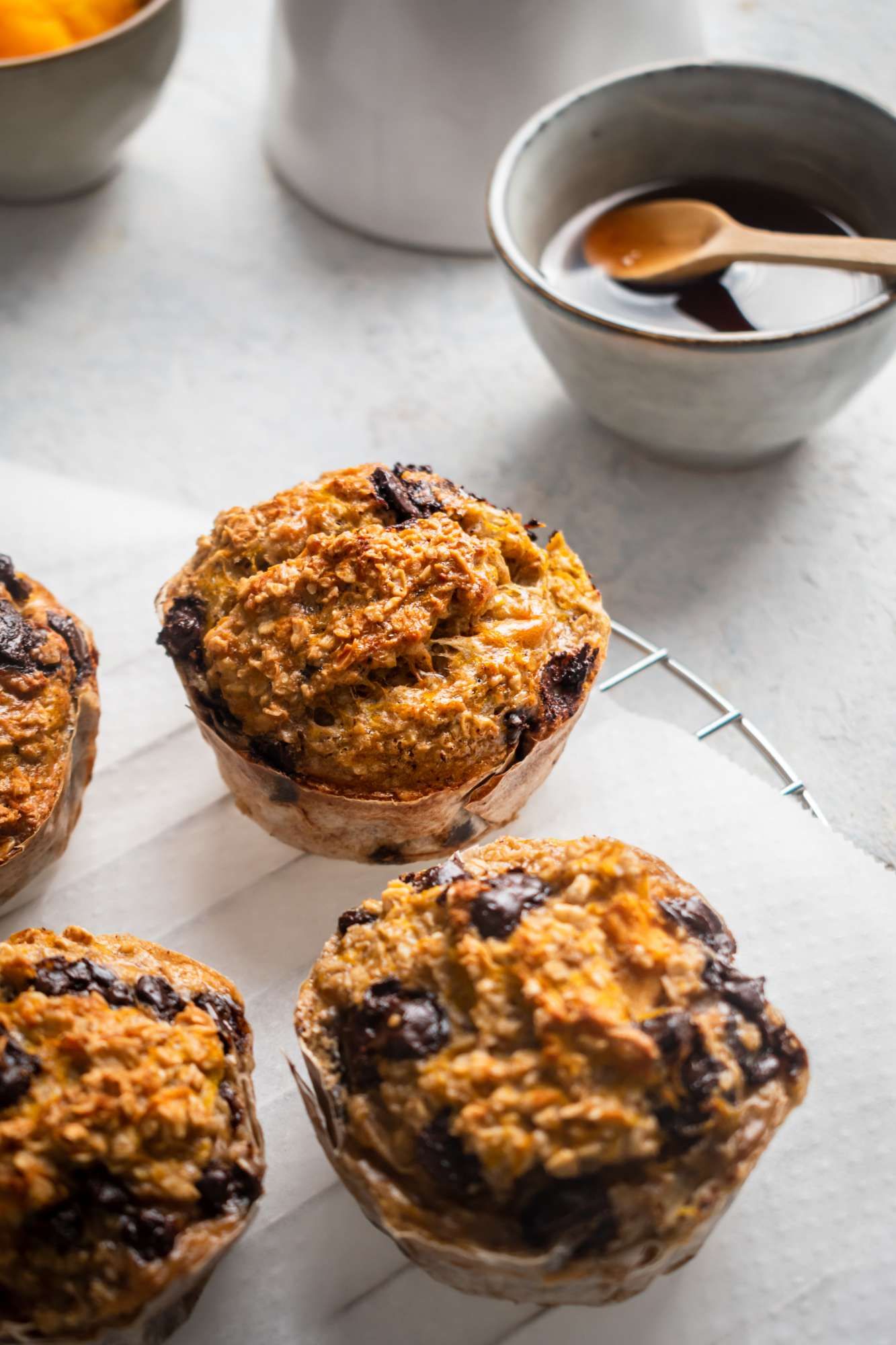 Pumpkin oat muffins cooked with canned pumpkin, rolled oats, and chocolate chips on a wire rack.