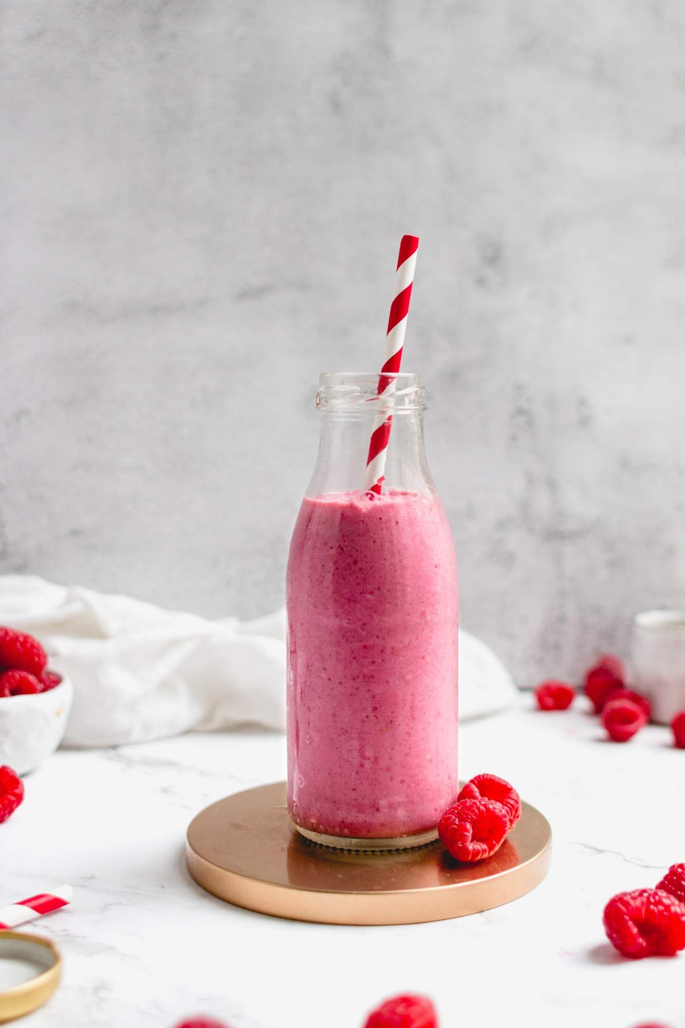 Raspberry smoothie with banana, chia seeds, flax seeds, and almond butter in a glass jar.