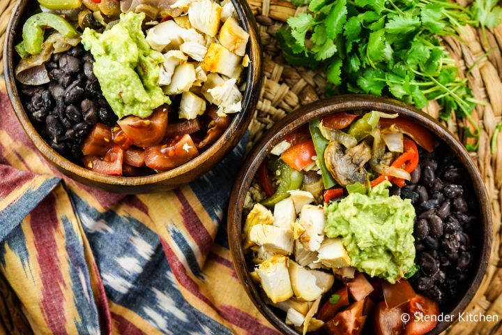 Rotisserie chicken taco bowl with black beans, bell peppers, onions, guacamole, and tomatoes.