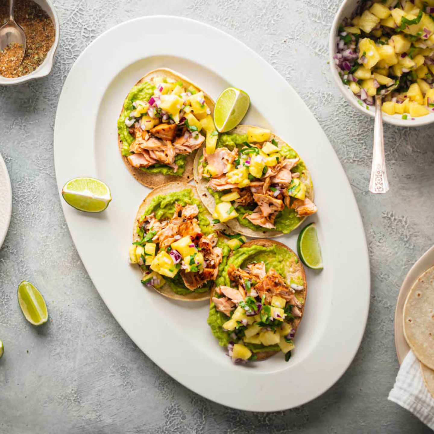 Salmon tostadas with creamy avocado, spice coated salmon, and pineapple salsa on crispy corn tortillas.