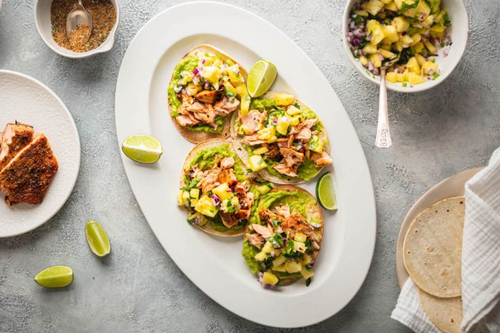 Salmon tostadas with creamy avocado, spice coated salmon, and pineapple salsa on crispy corn tortillas.