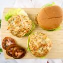 Shrimp burgers with lettuce and tomatoes on a wheat bun.