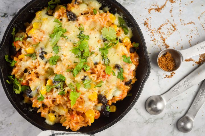 Mexican brown rice casserole with black beans, corn, tomatoes, bell peppers, and spices.