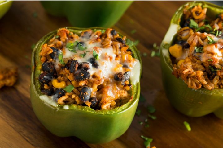 Slow cooked vegetarian stuffed peppers with black beans, corn, tomatoes, peppers, and melted cheese.