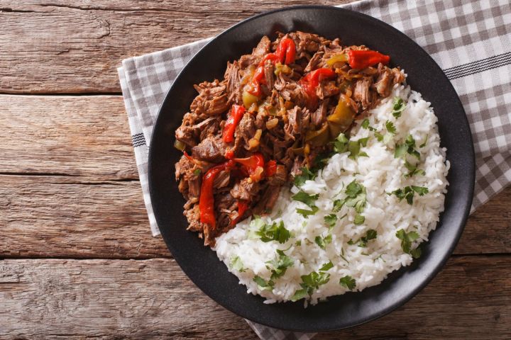 Slow cooker beef machaca with rice in a bowl with cilantro on top.