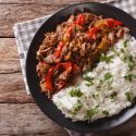 Slow cooker beef machaca with rice in a bowl with cilantro on top.