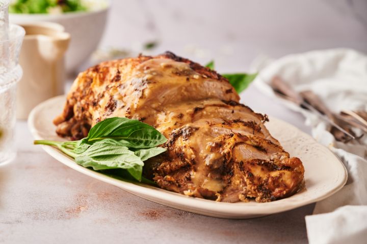 Crockpot boneless turkey breast sliced on a plate with homemade gravy.