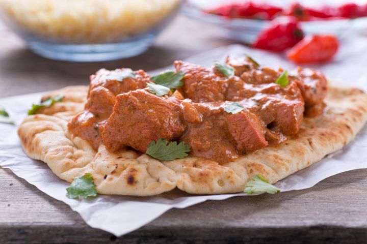 Slow Cooker Butter Chicken on a plate with white rice and cilantro.