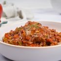 Slow cooker chicken cacciatore in a bowl with tomato sauce, chicken, mushrooms, and peppers over quinoa.