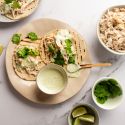 Slow cooker jalapeno chicken tacos with cilantro and Greek yogurt sauce served on corn tortillas.