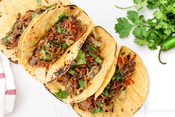 Slow Cooker Korean Beef Taco recipe with corn tortillas and Sriracha.