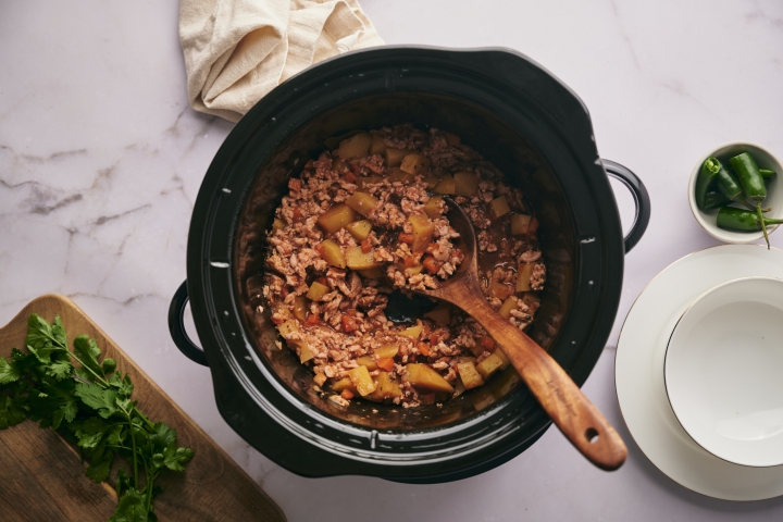 Slow cooker picadillo with ground meat, potatoes, and carrots with a spicy tomato sauce. 