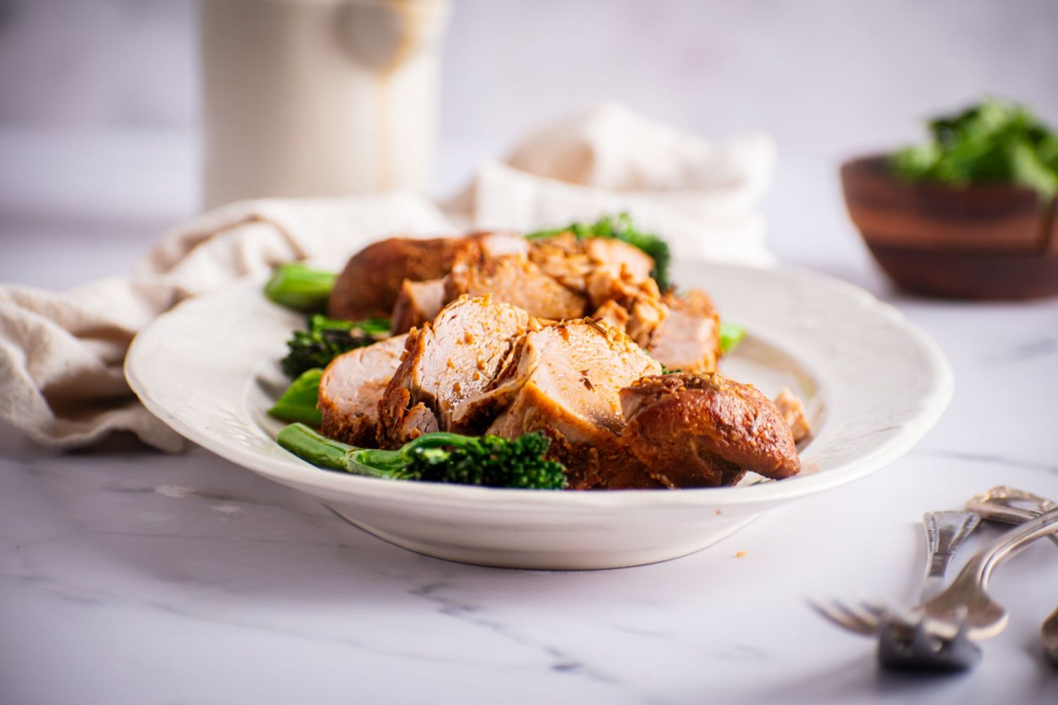 Sliced pork tenderloin that was cooked in the slow cooker served wit broccoli.