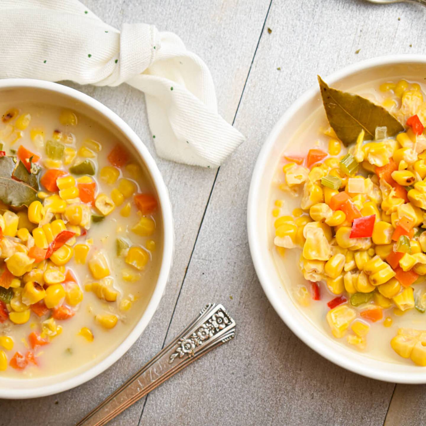 Slow cooker corn chowder with red peppers, carrots, celery, and poblano peppers in a creamy broth.