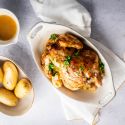 Slow cooker rotisserie chicken with a homemade spice rub, lemon, and parsley with potatoes on the side.