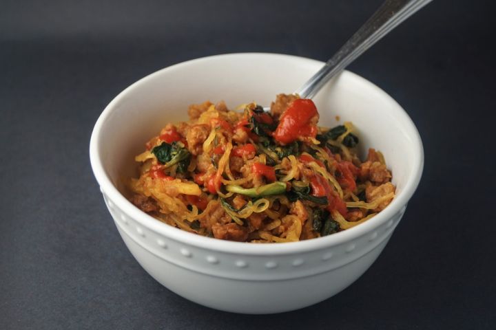 Asian spaghetti squash with crumbled sausage, spinach, spicy sauce, and cooked spaghetti squash noodles.