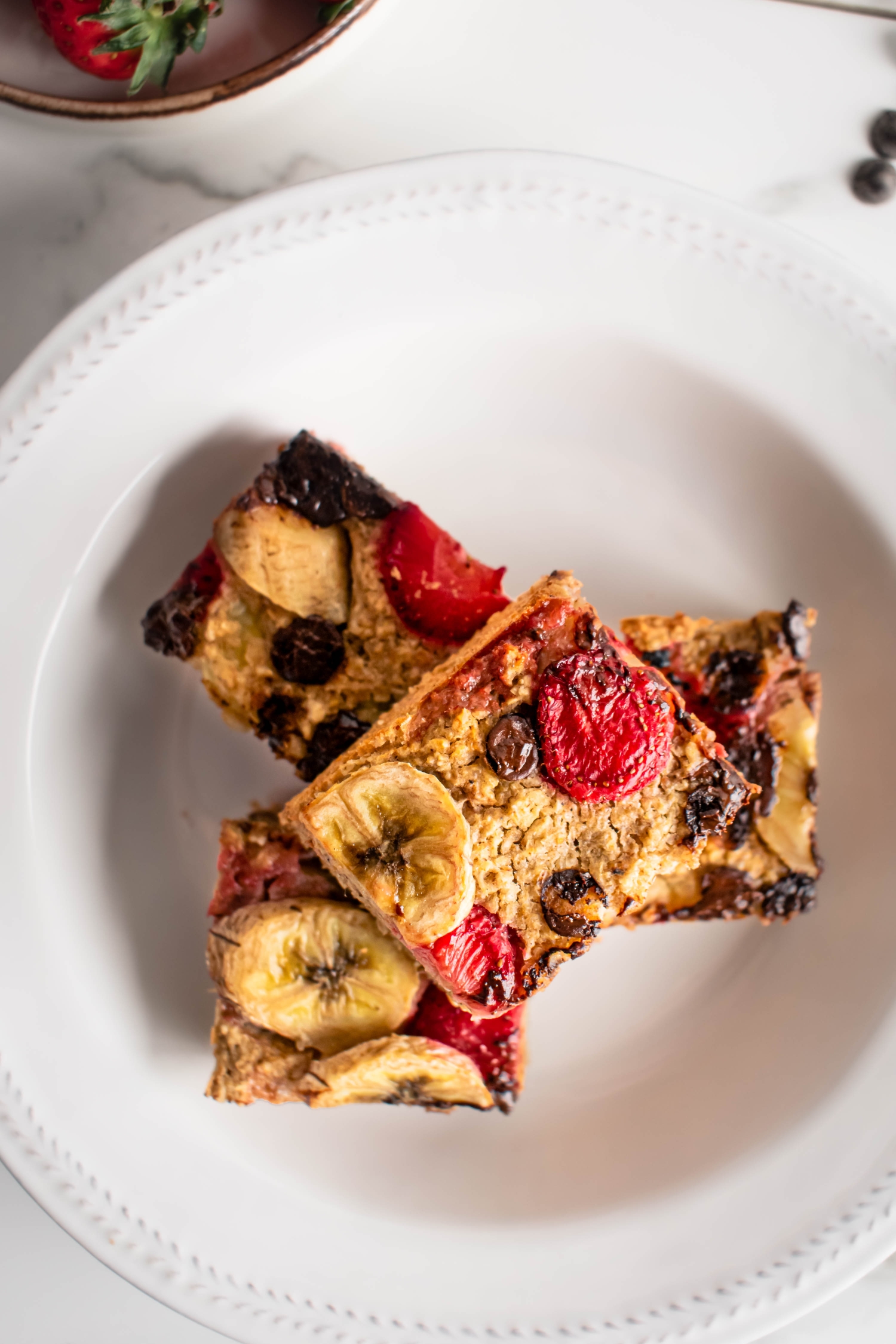 Baked strawberry oatmeal with sliced bananas and chocolate chips.