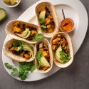 Sweet potato tacos with black beans, cauliflower, avocado, and cilantro served in corn tortillas. 