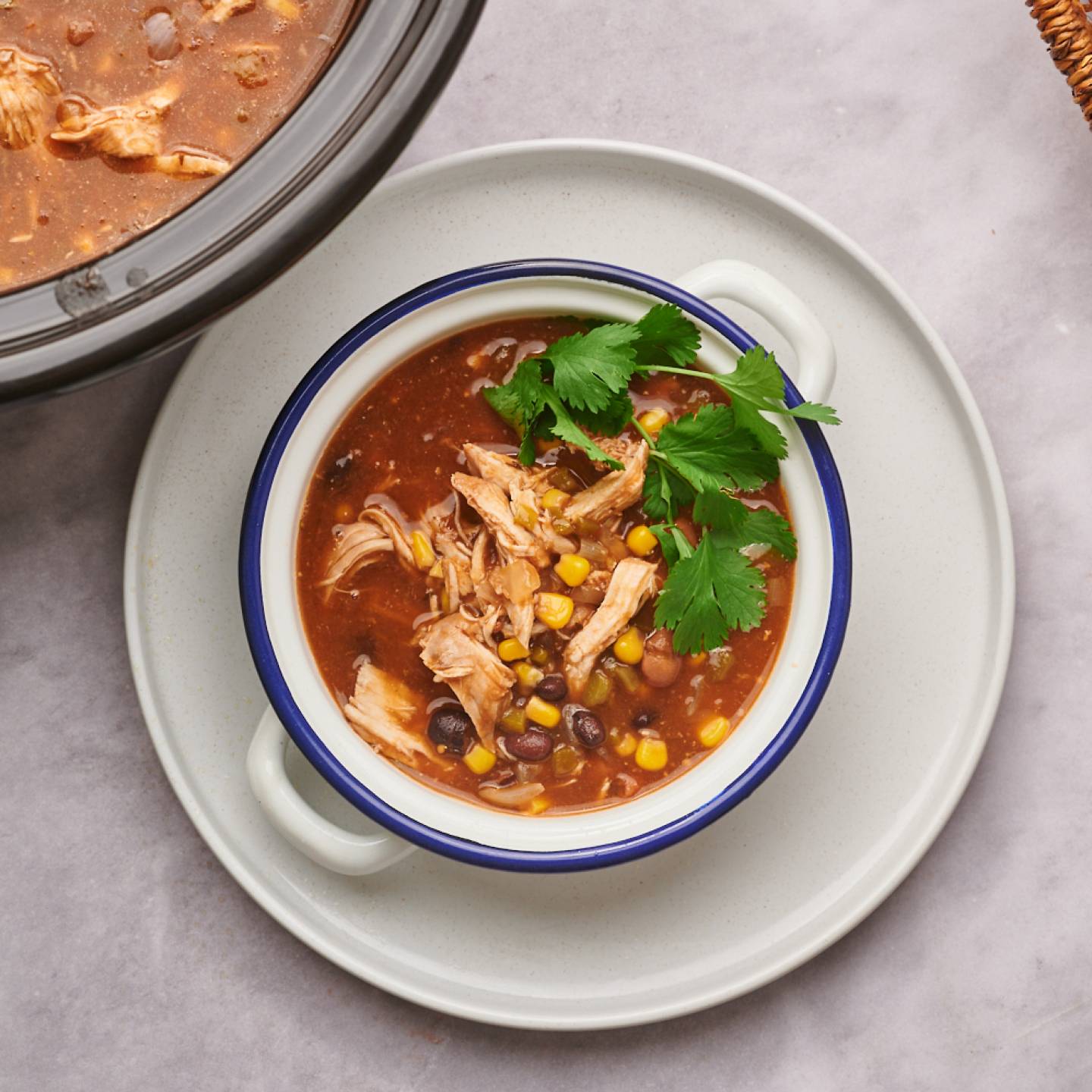 Healthy taco soup with black beans, pinto beans, shredded chicken, cilantro, and cheese.