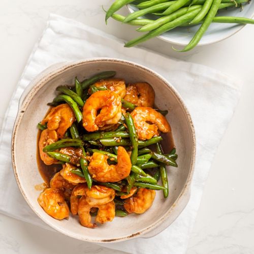 Teriyaki shrimp stir fry with green beans in a bowl with homemade sauce.