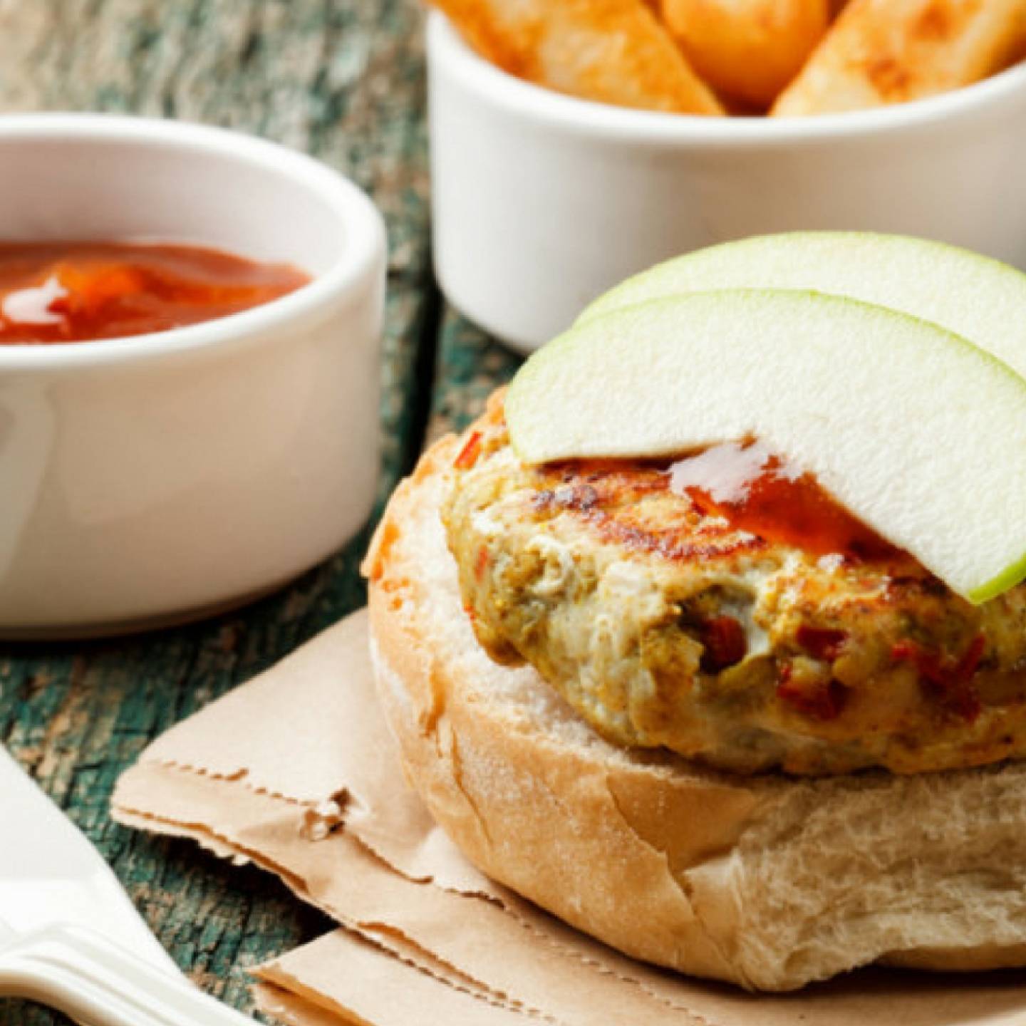 Turkey Apple Burgers on a bun with a slice of apple on top.