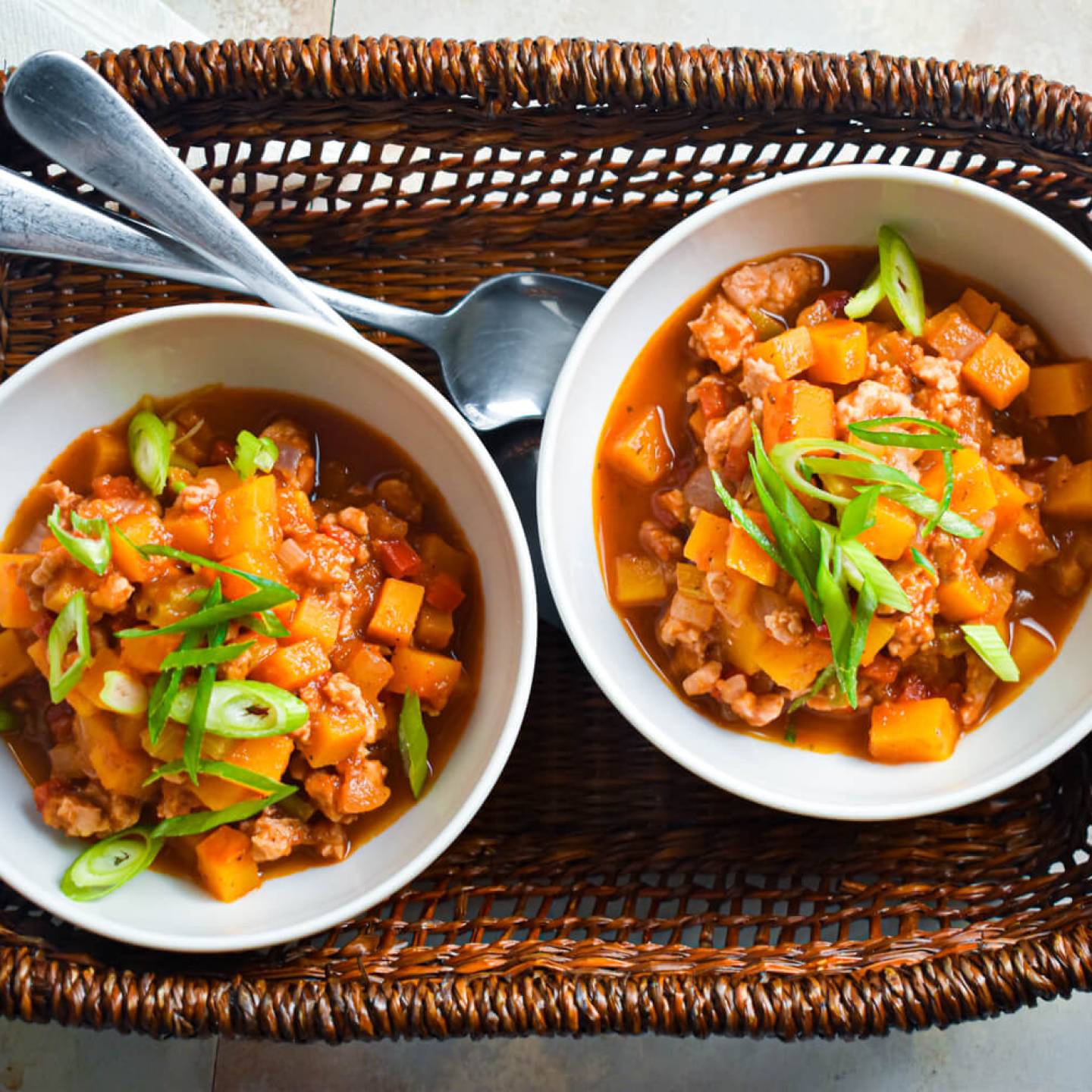 Turkey butternut squash chili with tomatoes, butternut squash, ground turkey, and sliced green onions.