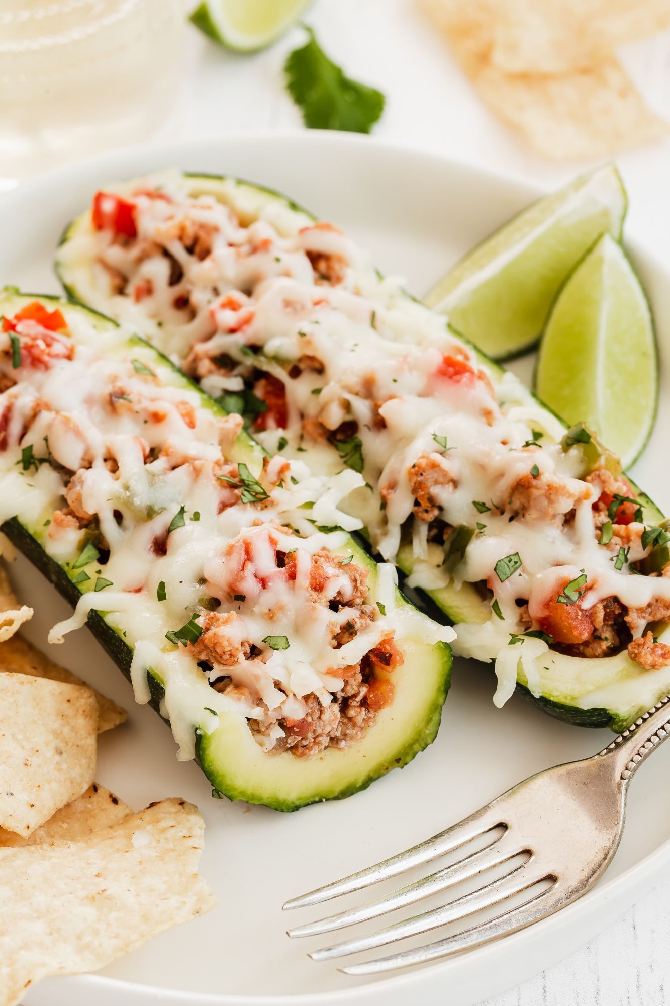 Fajita Zucchini Boats with turkey, tomatoes, onions, peppers, and cheese in a glass baking dish