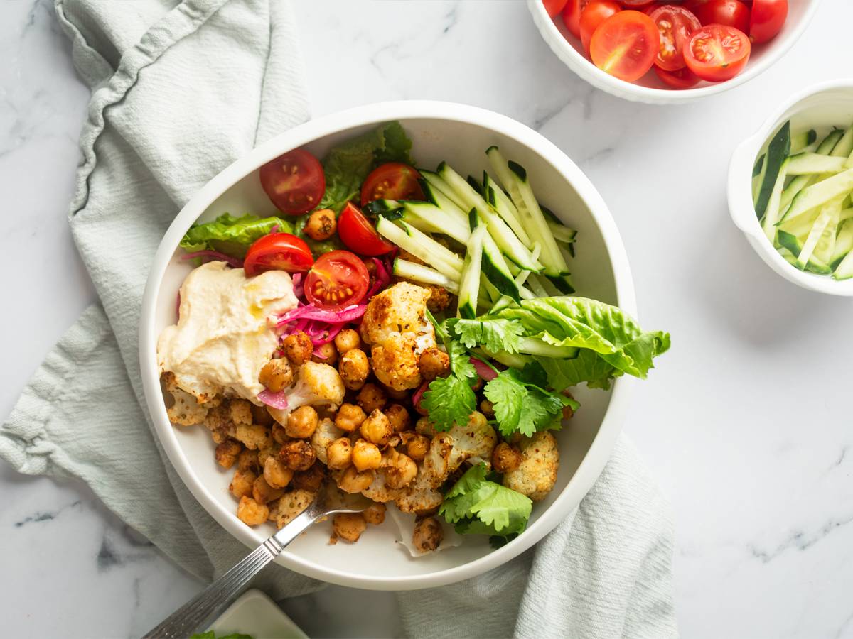 Vegetarain shawarma bowl with roasted chickpeas, cauliflower, and fresh vegetables.