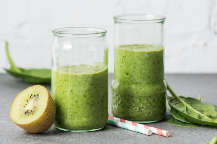 Pineapple cucumber smoothie with bananas, spinach, cucumber, and pineapple blended and served in two glasses.